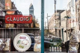 Claudio's, a staple in the market since the 1950s, displays imported items while reflecting both rehabbed and old facades on Montrose Street. Renters, owners, industrial, it's there. Rising above it all is the cupola of 124-year-olf St. Mary Magdalen de Pazzi church, the first Italian national parish in the U.S., closed for the last 15 years.